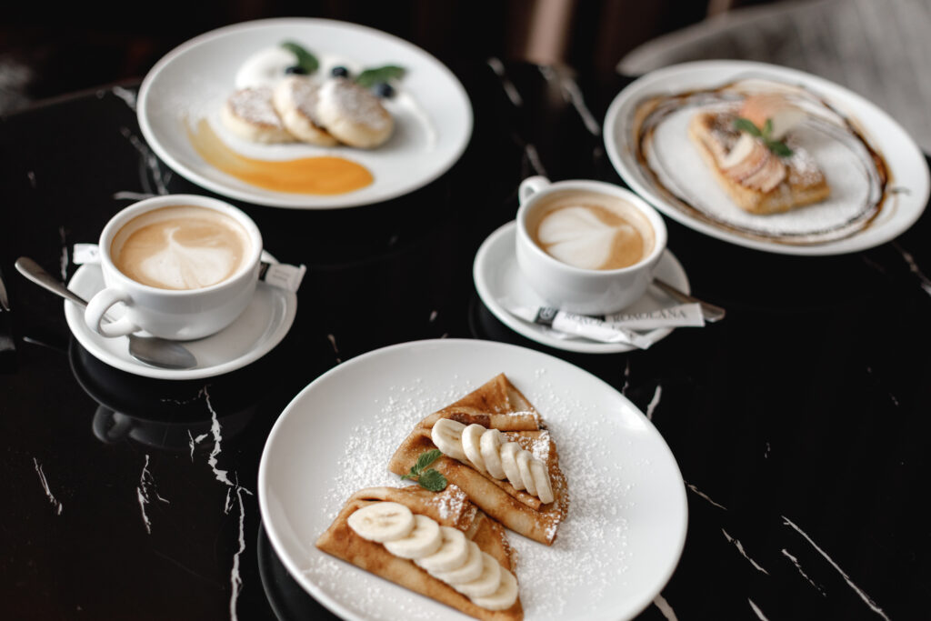 Leckerer Frühstückstisch mit einer Tasse Kaffee und köstlichen Palatschinken